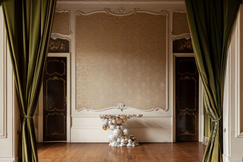 intimate luxury - contemporany living room with high walls in shades of brown , green curtains and marble white console 