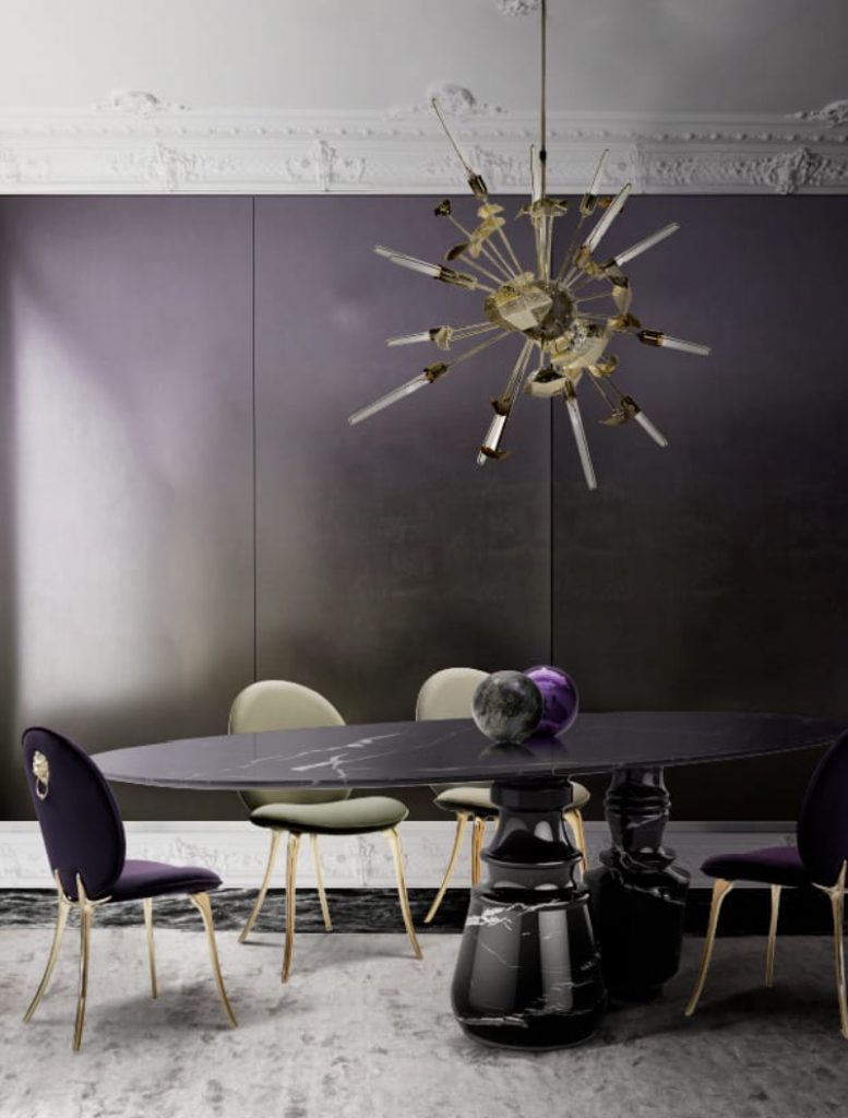 A dark dining room with a black marble dining table, green and purple dining chairs