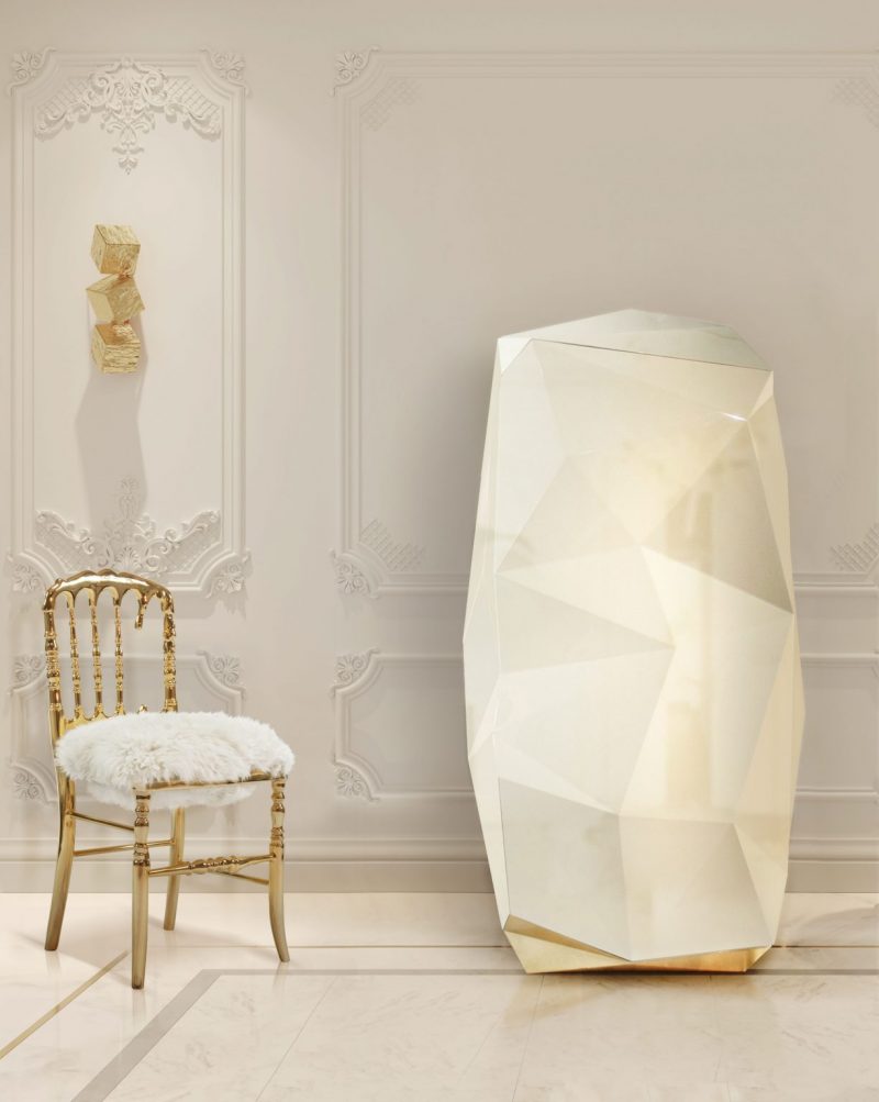 california home decor - gold chair and white fur, white walls, gold wall lamp, cream safe 