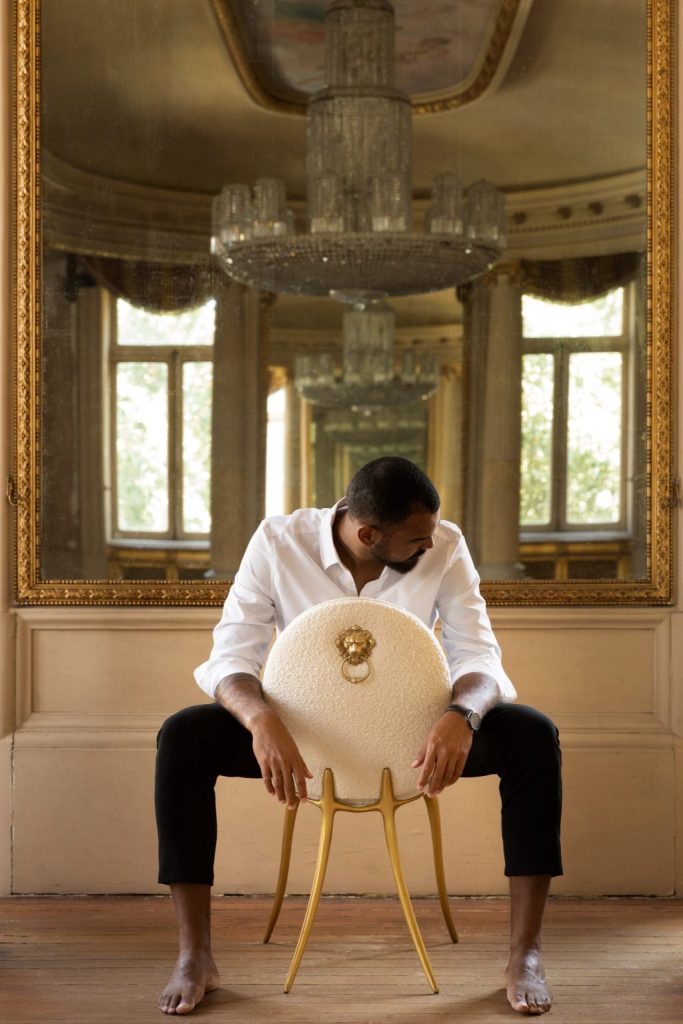 intimate luxury - living room with large gold mirror and a cream chair with golde details 