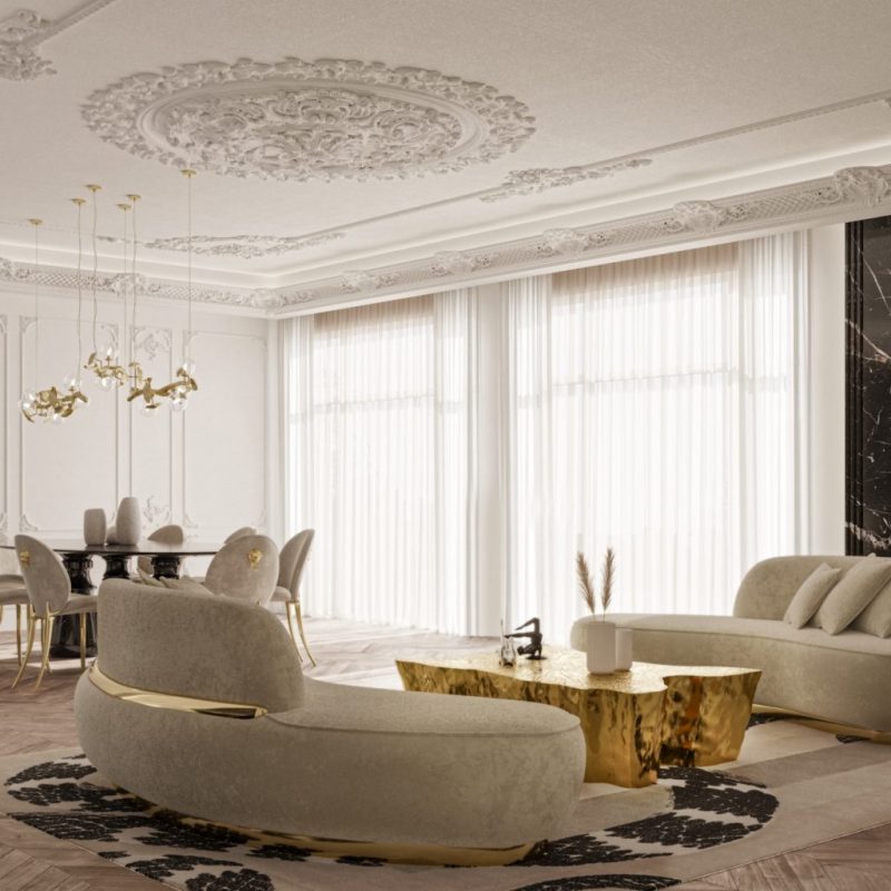 texas interior design- contemporary living room, large windows and white curtains, a rug, two cream sofas with gold details, gold coffee table with decorative items, black dining table, brown and gold chairs, gold hanging lamp  