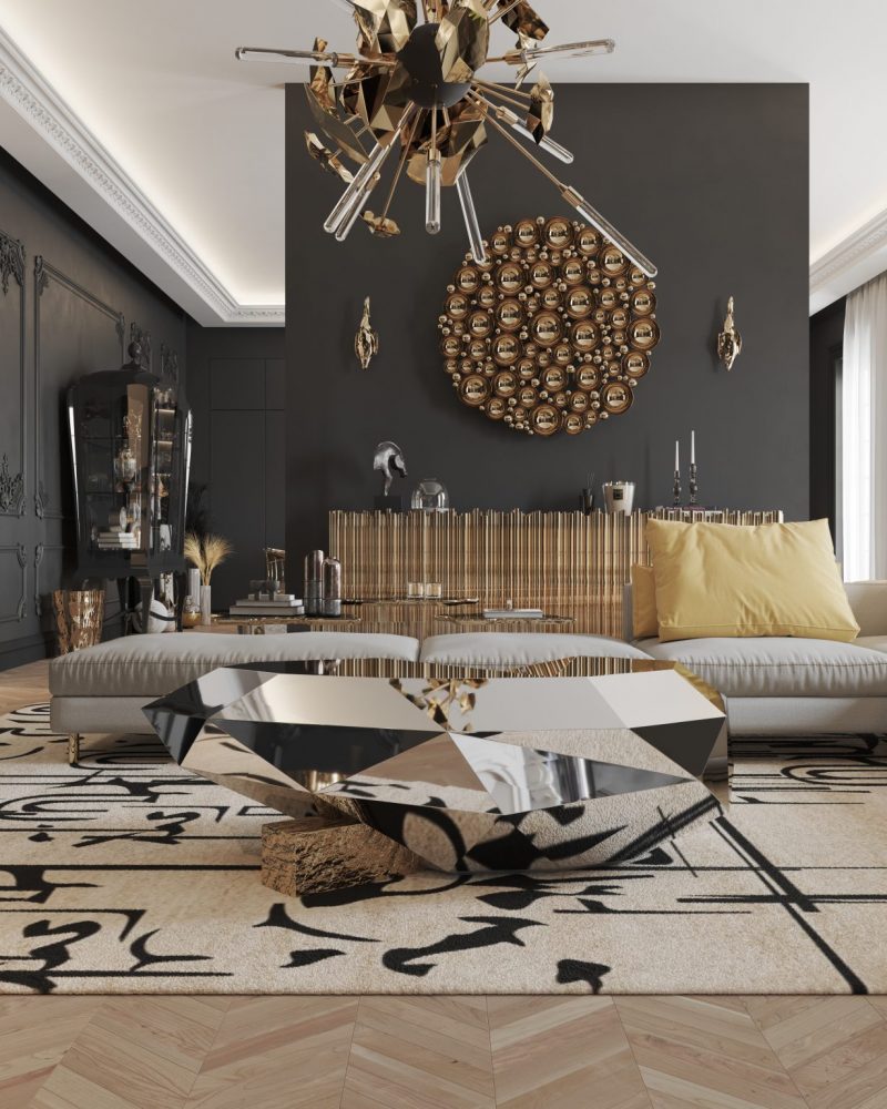 maximalism- dark living room, black walls, gold mirror, gold hanging lamp, gold sideboard, decorative items, gray sofa and silver coffee table  