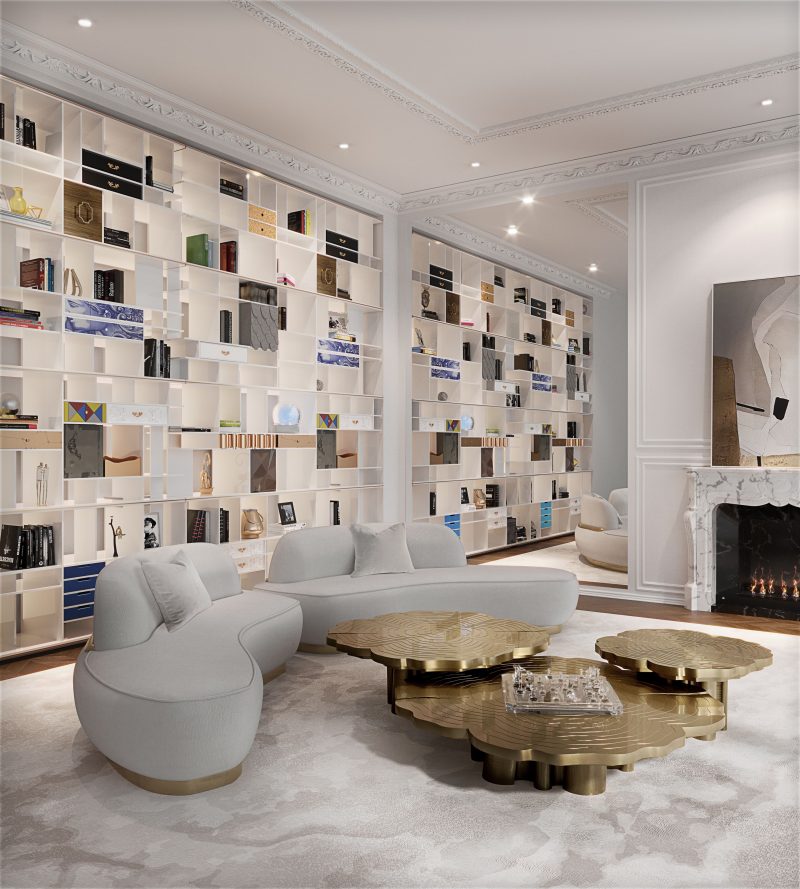 Three golden coffee tables in the shape of a tree, nude sofa in a curved shape and gold detail and a white bookcase with small details