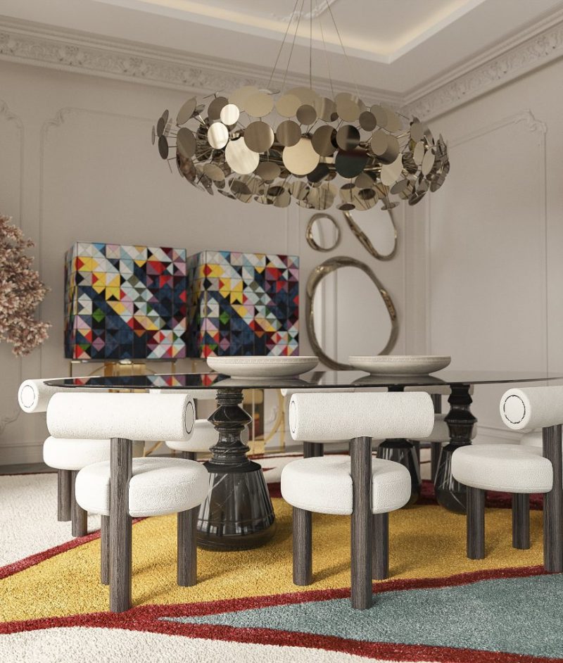 dining room wth black marble dining tale, nude dining chairs with dark wood features two multicolored cabinets and a statement mirror wall 